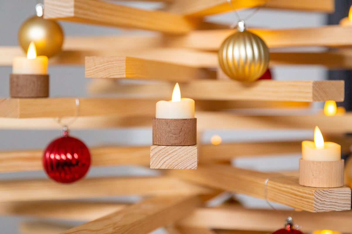 Bougeoir en bois avec bougie led posé sur une lame du sapin en bois